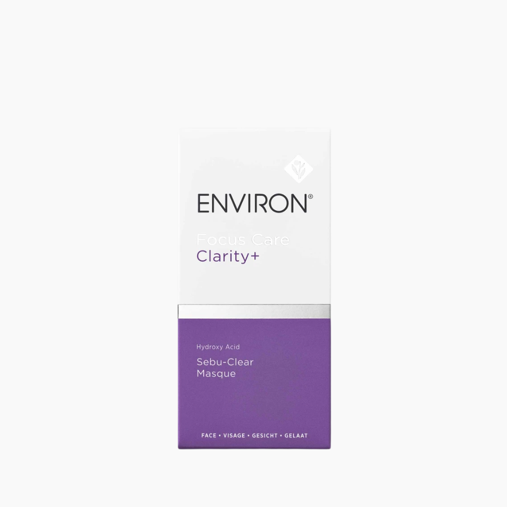 A rectangular skincare box for ENVIRON Clarity+ Sebu-Clear Masque, featuring a white top half with black and purple text, and a purple bottom half, centered on a light gray background.