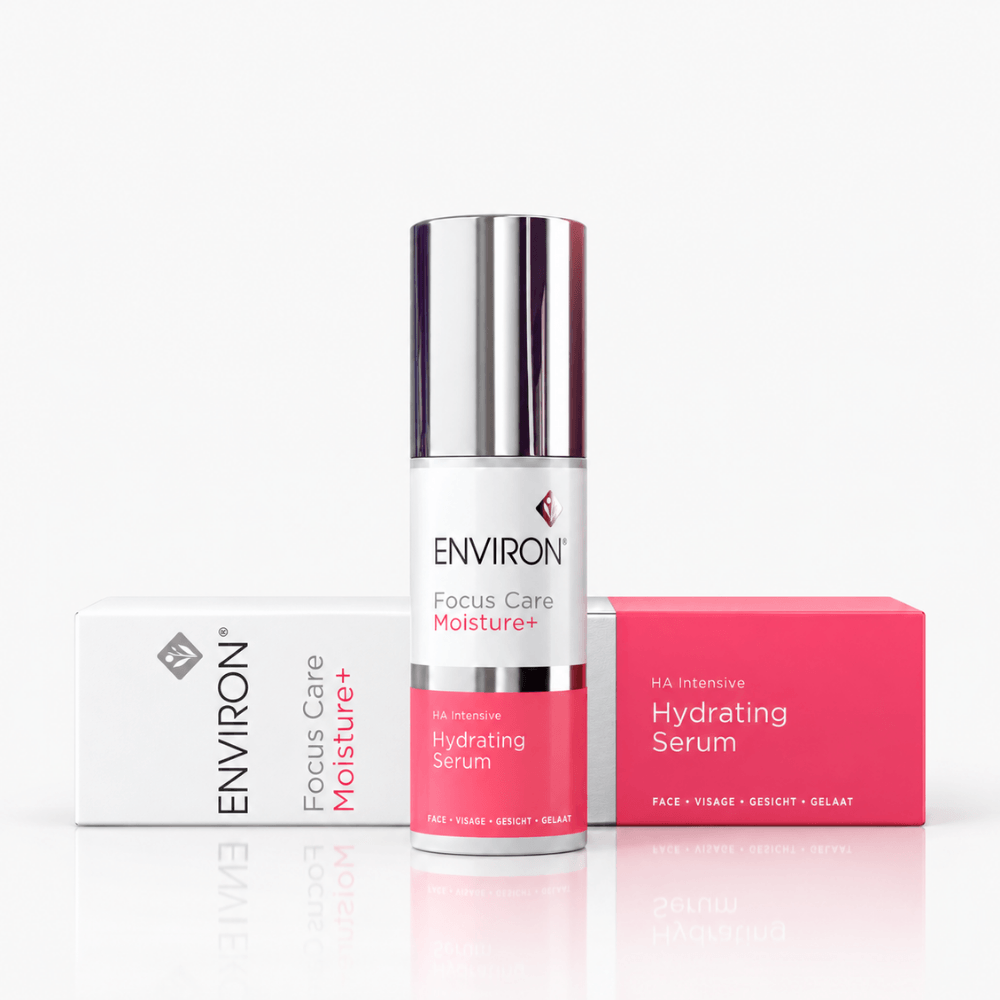A skincare product set featuring a cylindrical bottle of ENVIRON Focus Care Moisture+ Hydrating Serum in the center, flanked by its white and pink retail boxes on a clean white background.