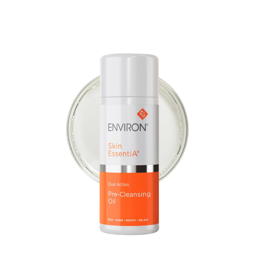 A white bottle of Environ Skin EssentiA Pre-Cleansing Oil with a green and white label. The cylindrical bottle contains 100ml of plant and oil-based pre-cleanser designed to dissolve excess surface oil and remove environmental pollutants. This pre-cleanser helps refresh and nourish the skin while maintaining its natural moisture barrier and pH balance. Ideal for preparing the skin for further cleansing and treatment, it features a screw-on cap.